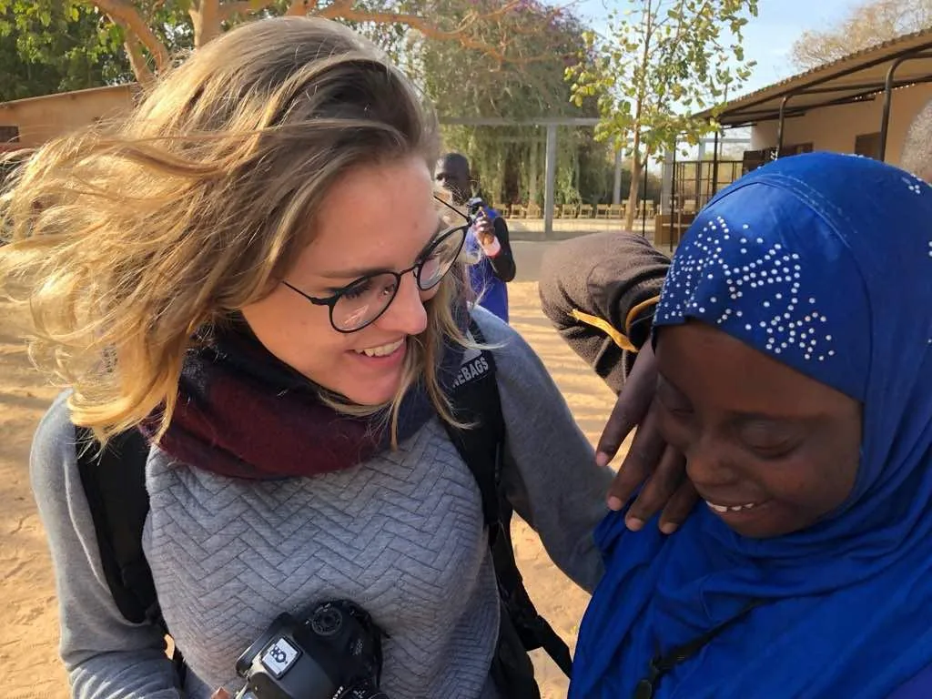 Kaina, appareil photo à la main, en échange avec une femme lors d'une mission