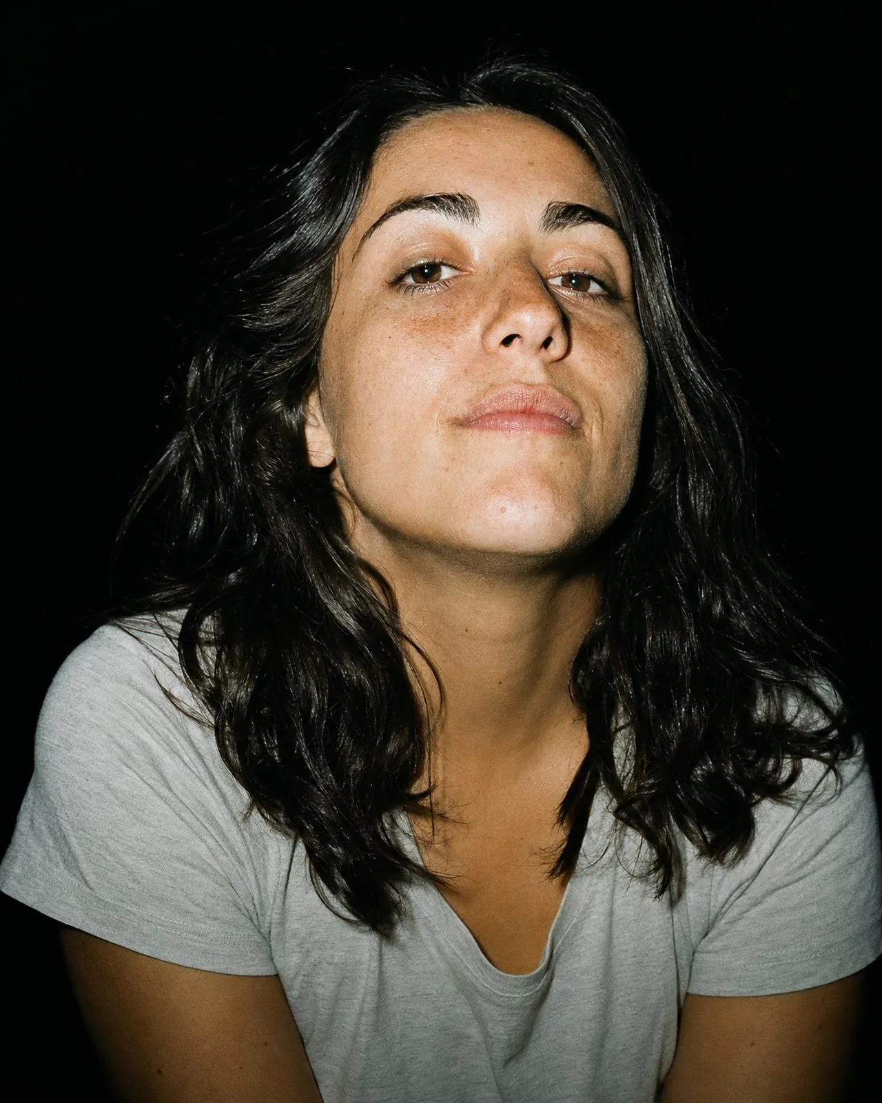 Portrait au flash d'une femme qui regarde l'objectif, calme et déterminée