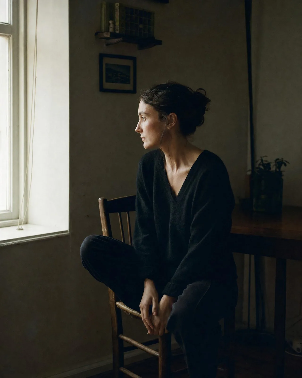 Portrait d'une femme seule près d'une fenêtre, calme et recueillie