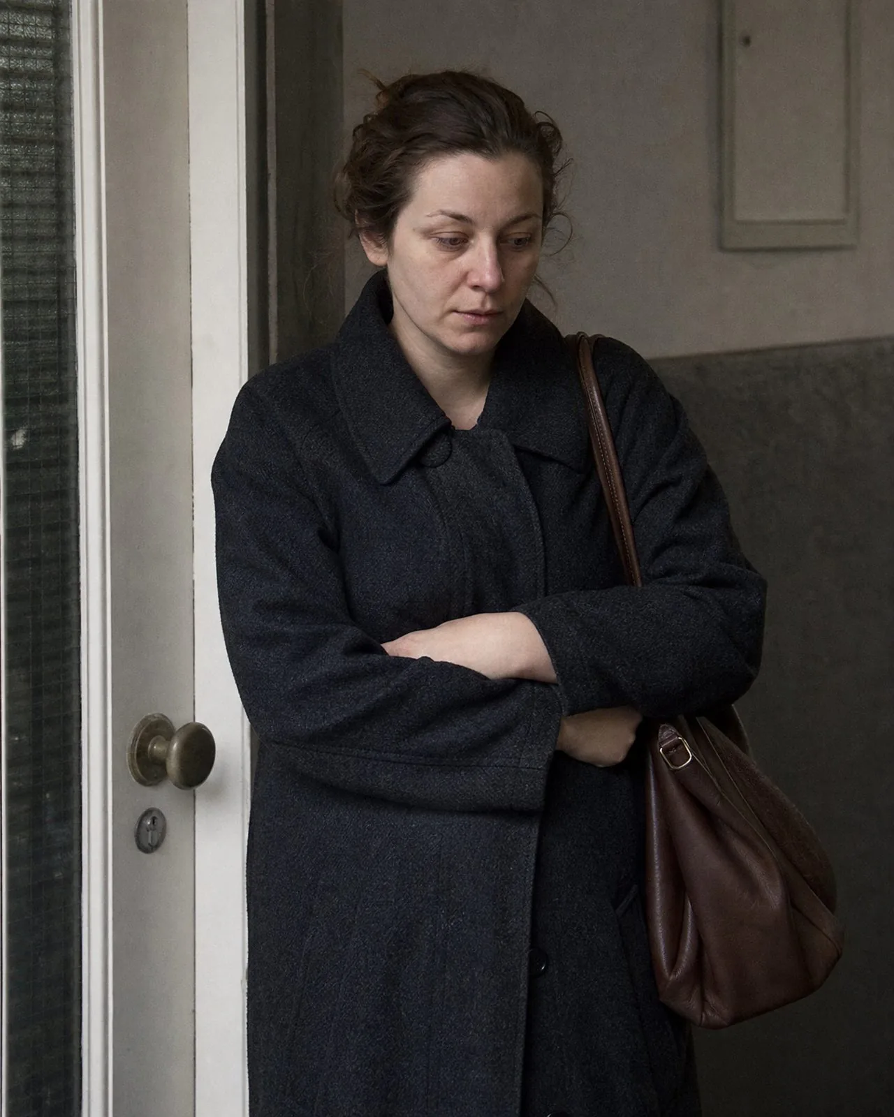Camille arrive, encore en manteau, les bras croisés sur le ventre