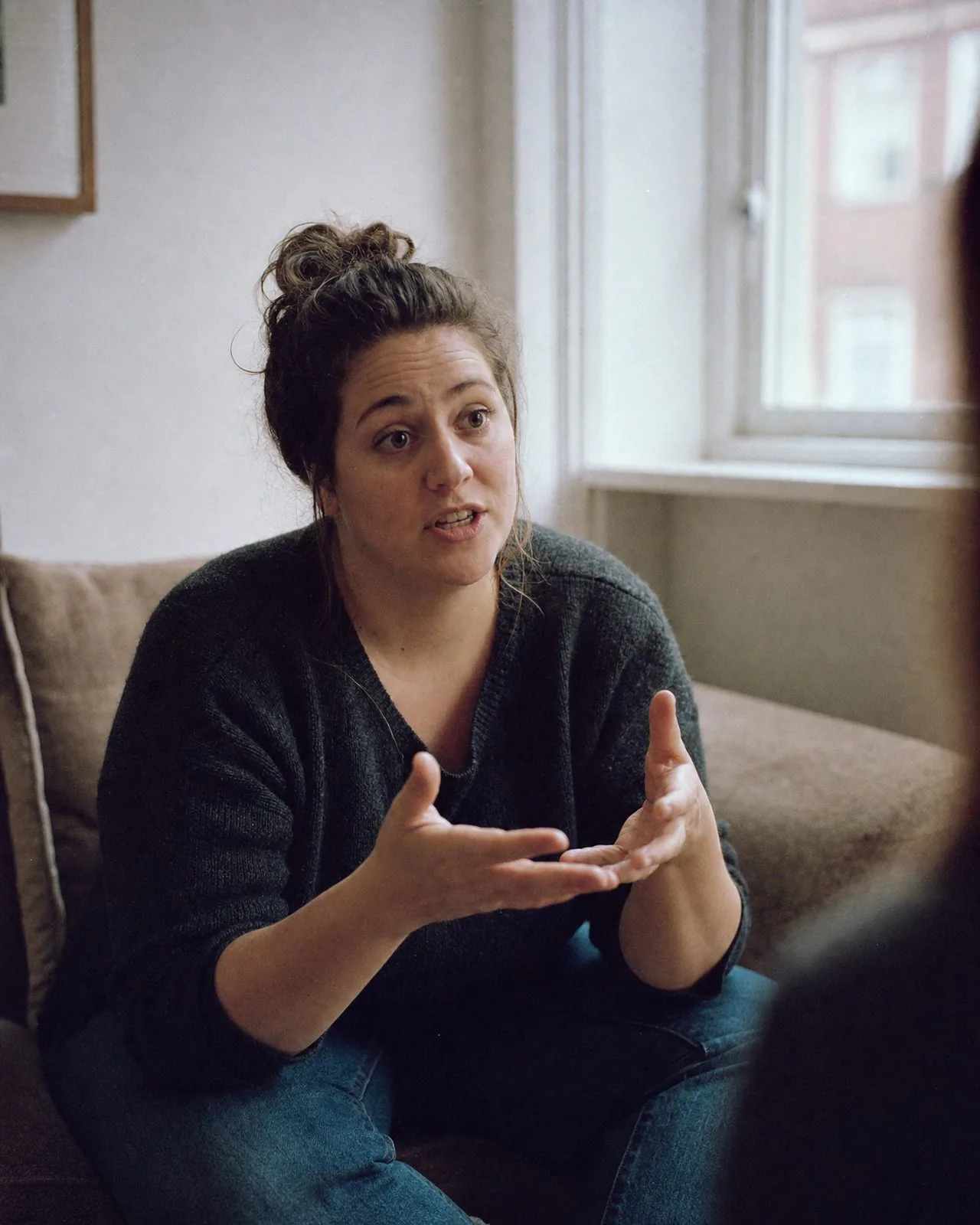 Camille en conversation, penchée en avant, les mains qui parlent