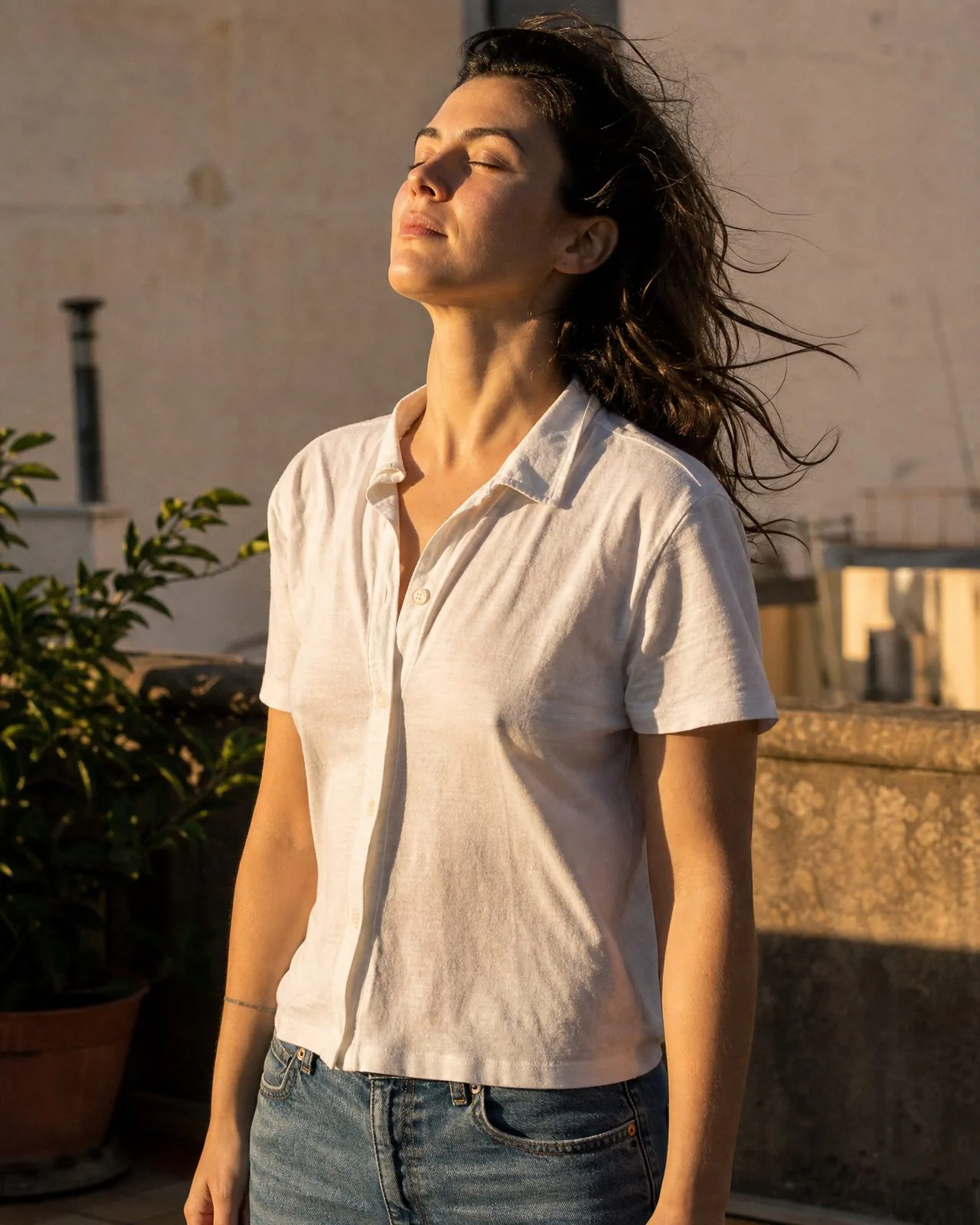 Sarah dehors, les yeux fermés, le visage tourné vers le soleil